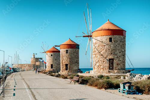 Windmills and saint Nicholas fortess in Mandraki harbor in Rhodes city, Greece