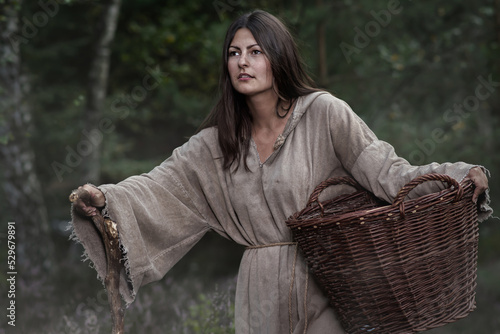 Medieval young poor girl in the forest
