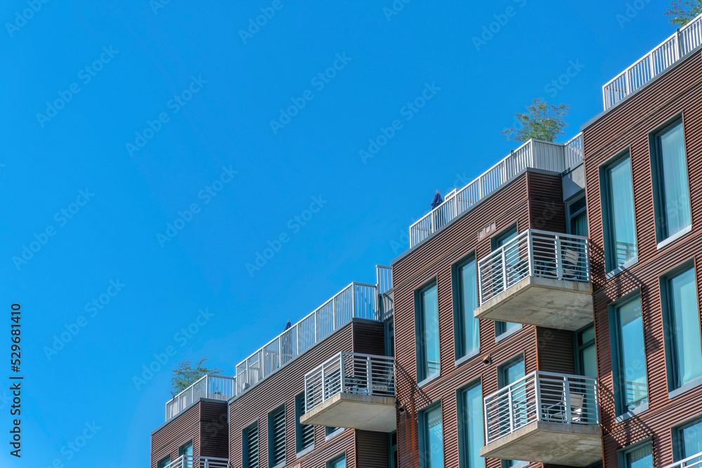 Exterior view of a luxury modern apartment with balconies against blue sky