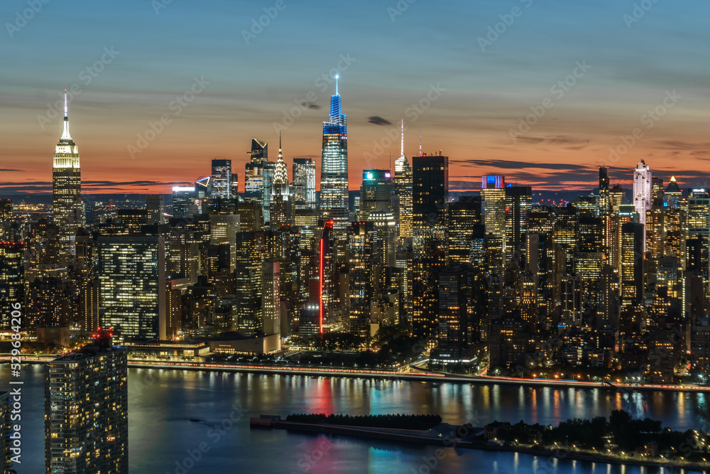 Fototapeta premium Aerial view of New York city, Empire State Building, Chrysler Building, One Vanderbilt, 30 Rock at sunset and twilight