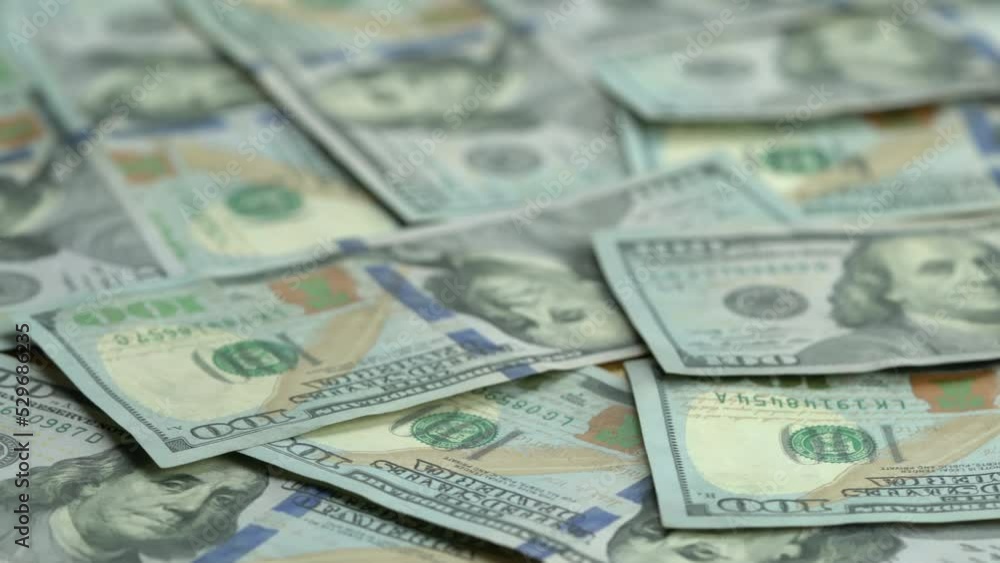 Closeup view rotation of new green one hundred us dollar bills spreading cover on top of a table.
Closeup view rotation of new green one hundred us dollar bills spreading cover on top of a table.