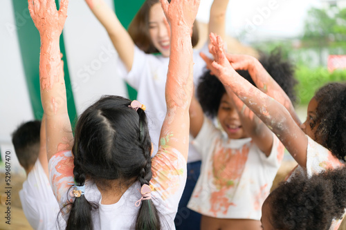 Children have fun playing with colors. They are holding hands