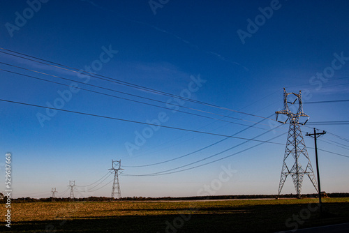 Large power pylon columns and lines running in a line in the country