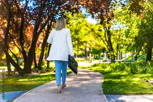 Coffee break - beautiful woman walking in city park