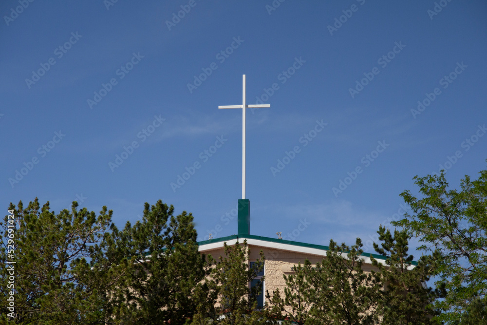 White Cross on top of Church against the Blue Sky