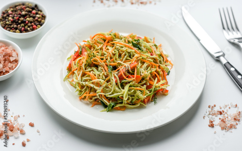 Fresh salad of sliced thin strips of carrot and zucchini on a concrete background
