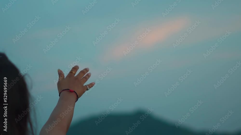 Close up shot of hand of a girl reaching out to the sky during sunset. Female extends her hand towards the sky in search of hope. Hopelessness in a woman. Looking for answers and reaching for sky. Close up shot of hand of a girl reaching out to the sky during sunset. Female extends her hand towards the sky in search of hope. Hopelessness in a woman. Looking for answers and reaching for sky.