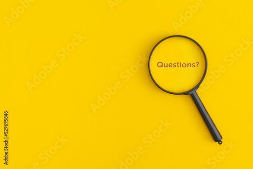 Magnifying glass with the word Questions on a yellow background
