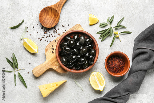 Fototapeta Naklejka Na Ścianę i Meble -  Composition with plate of tasty black olives, spices and lemon on light background