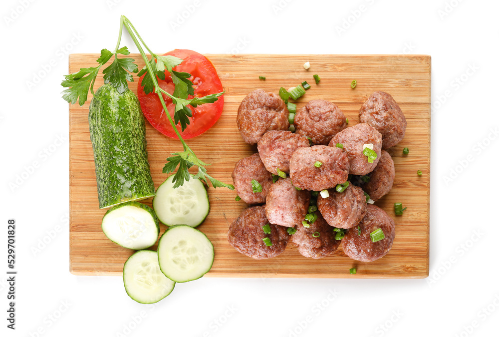 Wooden board with tasty meat balls and vegetables on white background