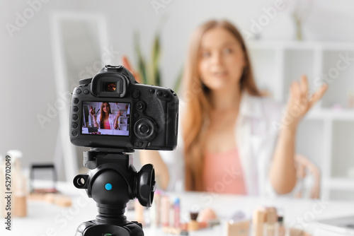 Female beauty blogger with lipstick on screen of camera in dressing room, closeup