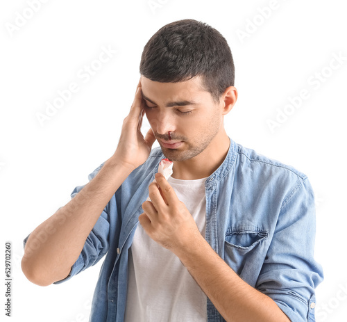 Young man with nosebleed an...