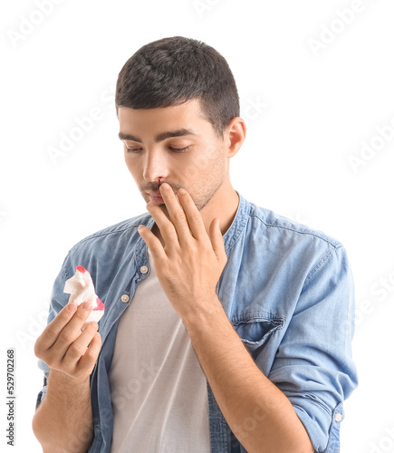 Young man with nosebleed an...