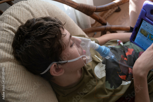 12 year old boy with special needs getting a nebulizer treatment for asthma photo