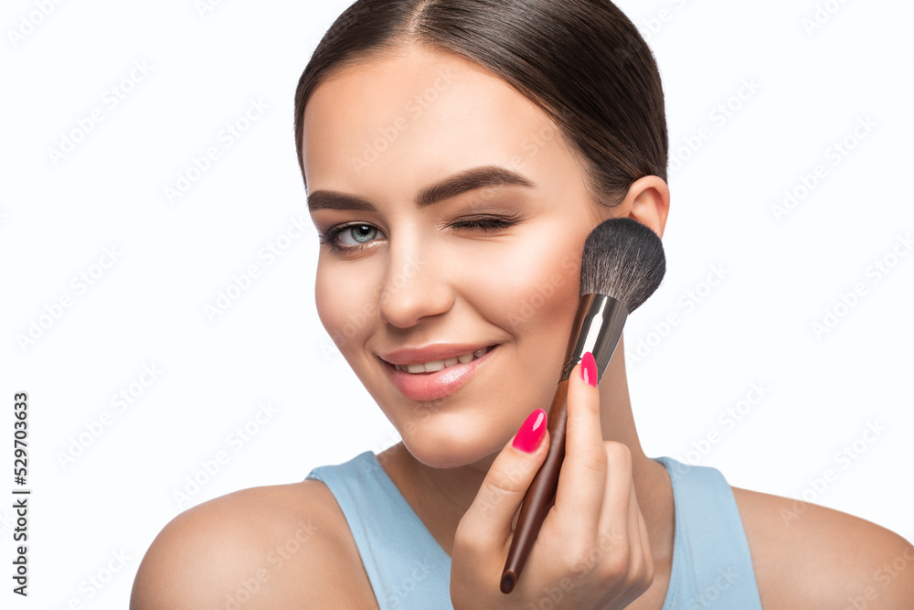 Portrait of a brunette girl with beautiful fresh makeup and healthy clean skin. She holds a powder brush in her hands. Professional makeup concept Portrait of a brunette girl with beautiful fresh makeup and healthy clean skin. She holds a powder brush in her hands. Professional makeup concept