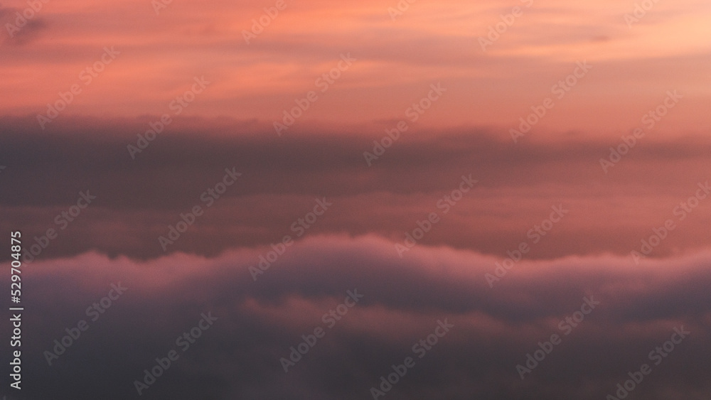 foggy sky during dusk - clouds and mist over mountains and beautiful orange sky