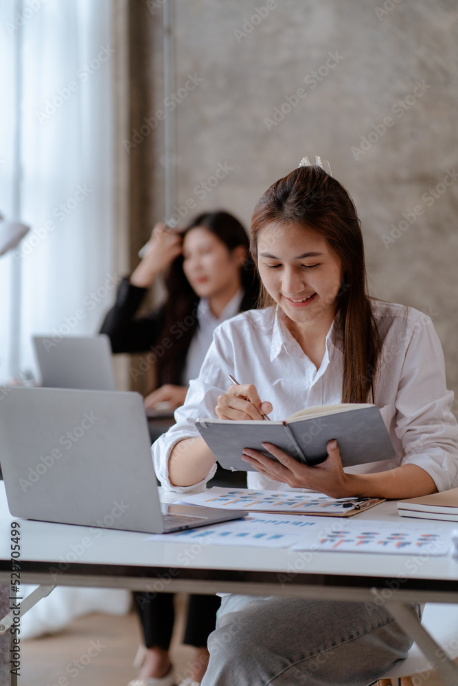 Young Asian business women are delighted and happy with their work and success on their laptop at home. Young Asian business women are delighted and happy with their work and success on their laptop at home.