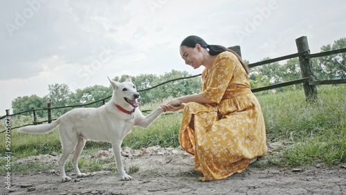 Fotografija Happy woman petting dog in countryside