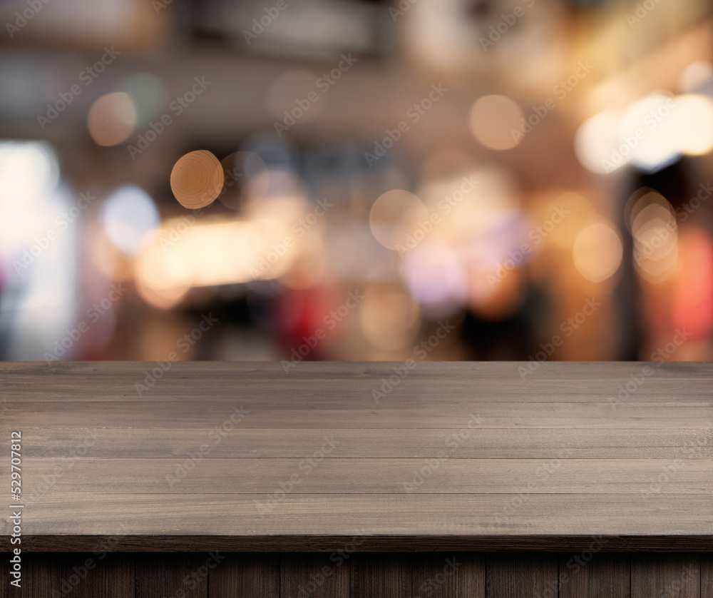 Empty wooden surface and blurred view of clothes store interior. Space for design