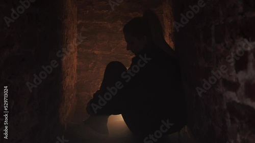War in Ukraine. Gunning of civilians. Ukrainian girl sits in a bomb shelter. Military action in Ukraine. The woman is hiding in the basement. Air Raid photo