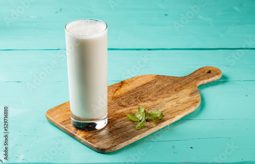 Ayran Laban or sweet lassi with milk and yogurt served in a glass isolated on cutting board side view healthy drink