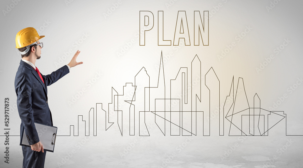 Businessman in hard hat holding blueprint Businessman in hard hat holding blueprint