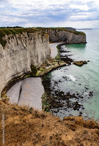 Landscape view of cliffs of Etretat Normandy France. Lighthouse in background.