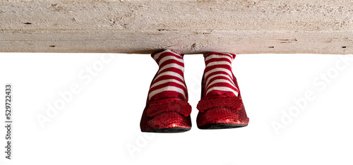 Red and white stripe socks with red ruby slippers isolated under a wood board