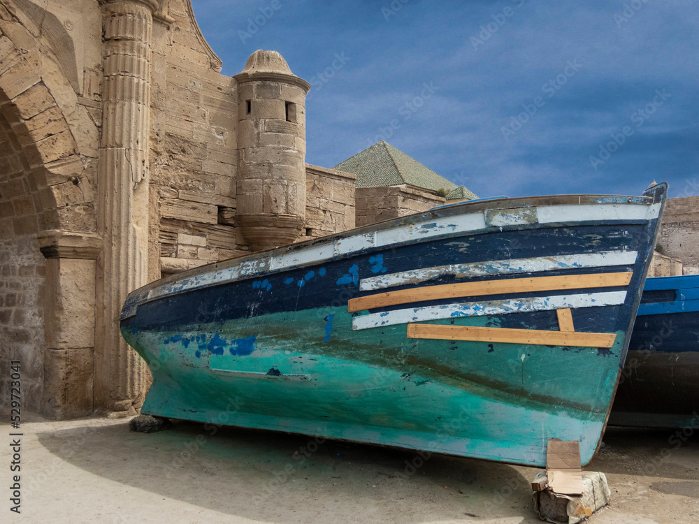 Boat by an ancient building in a Moroccan port