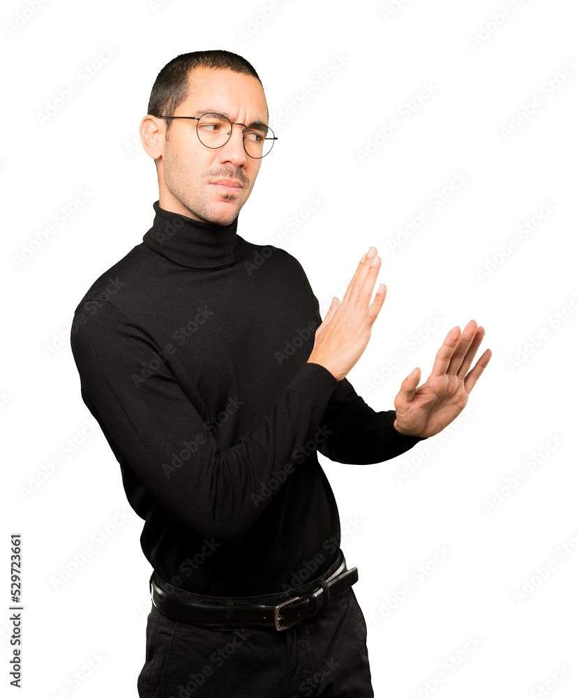 Doubtful young man doing a gesture of keep calm Doubtful young man doing a gesture of keep calm