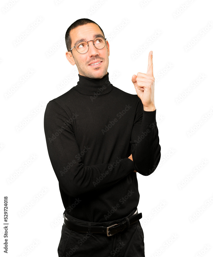 Happy young man pointing up with his finger Happy young man pointing up with his finger