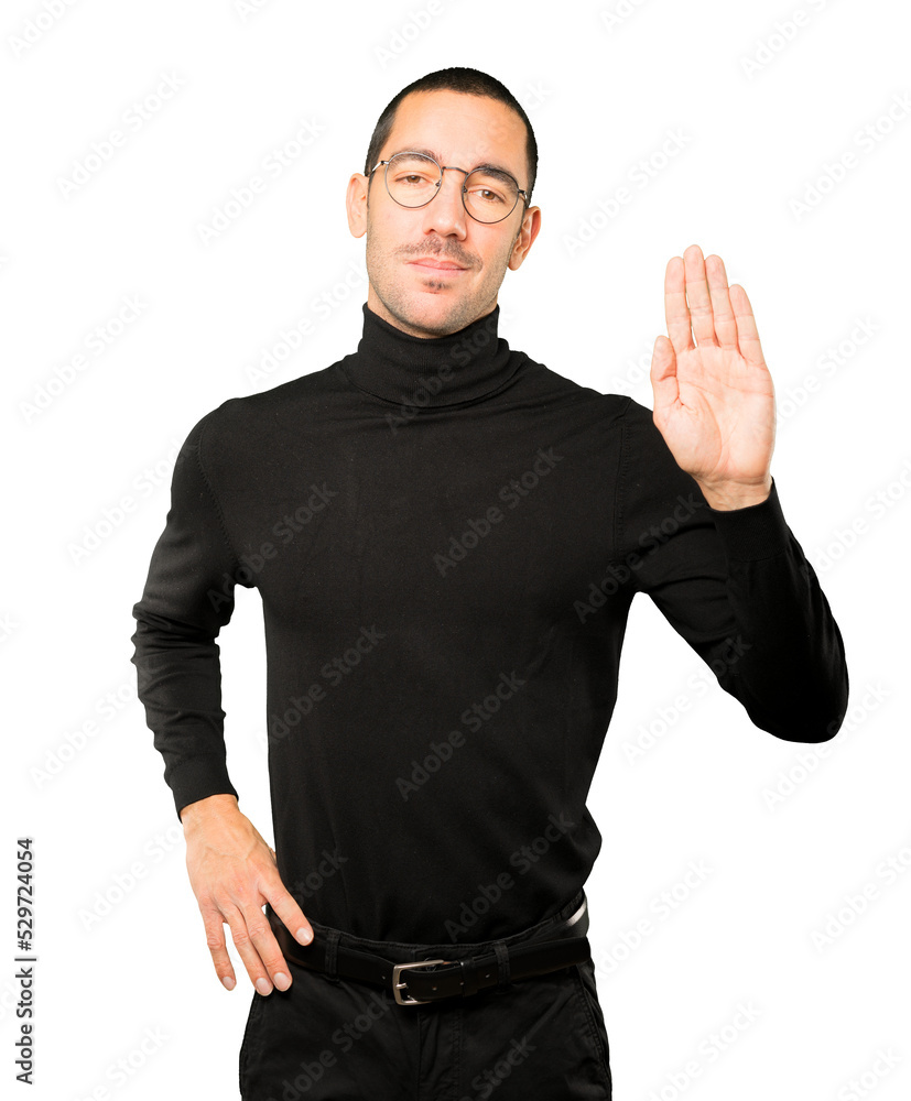 Serious young man making a gesture of stop with his palm Serious young man making a gesture of stop with his palm