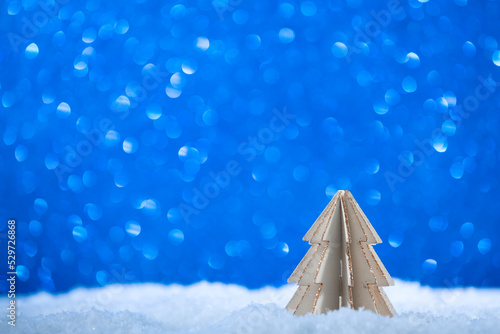 Small wooden Christmas tree on snow and blue bokeh background.Postcard happy new year .Copy space © SNAB