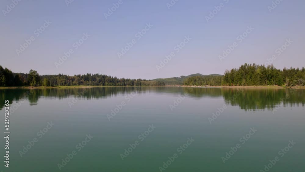 Flying low over the reflective surface of bluish green water of Lake Alder and then ascending to approximately 400’ on a hazy September morning. Flying low over the reflective surface of bluish green water of Lake Alder and then ascending to approximately 400’ on a hazy September morning.