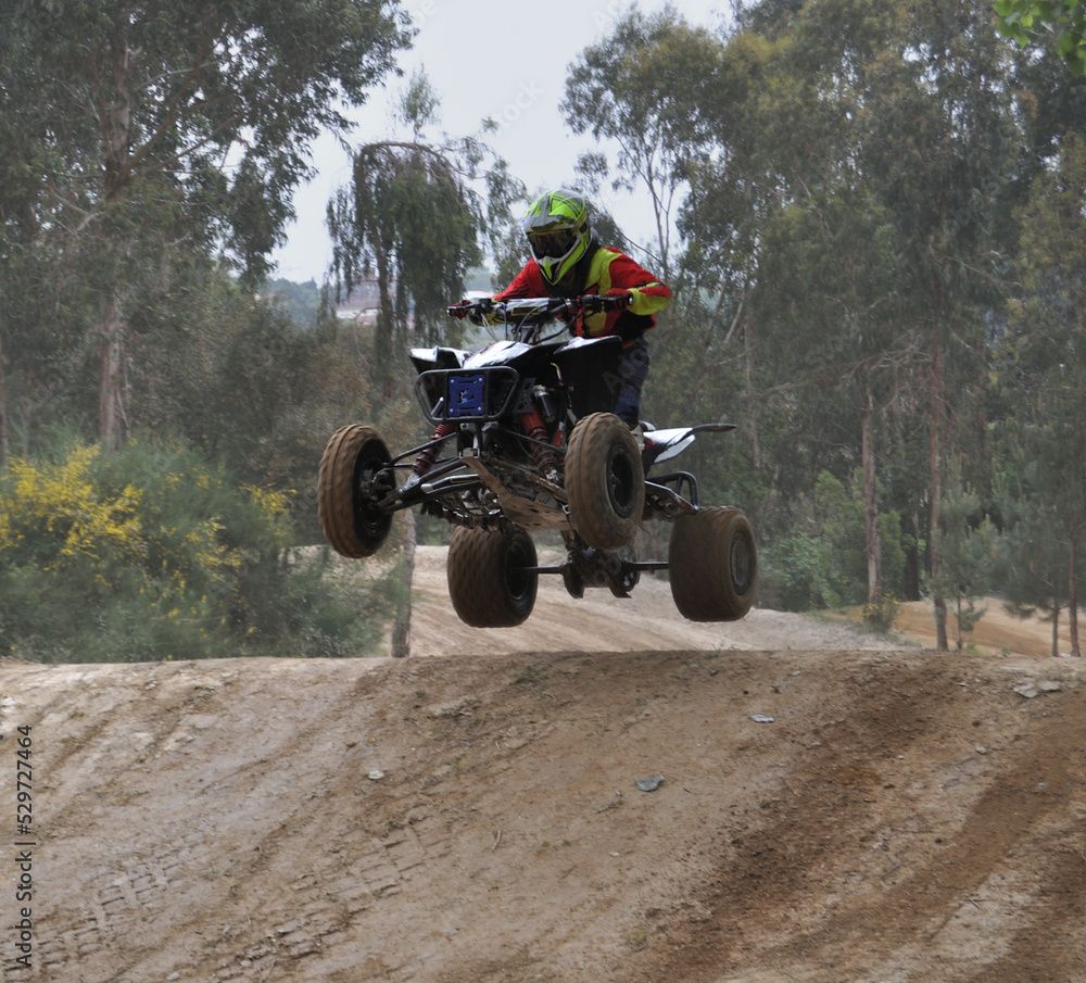 Pessoa a andar de moto quatro em todo o terreno num caminho de terra batida de montanha, aventura, salto Pessoa a andar de moto quatro em todo o terreno num caminho de terra batida de montanha, aventura, salto