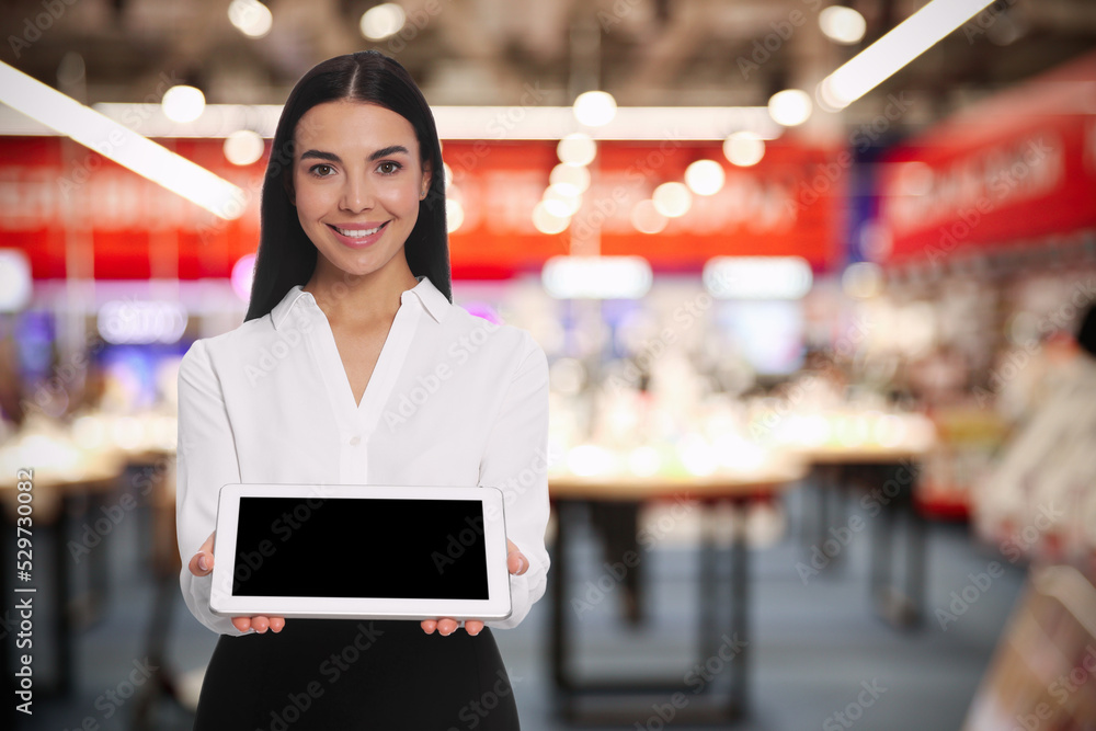 Portrait of hostess wearing uniform with tablet in shopping mall. Space for text Portrait of hostess wearing uniform with tablet in shopping mall. Space for text