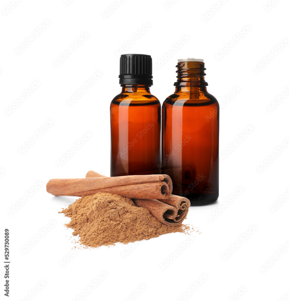Bottles of natural essential oil, dry cinnamon sticks and powder on white background Bottles of natural essential oil, dry cinnamon sticks and powder on white background