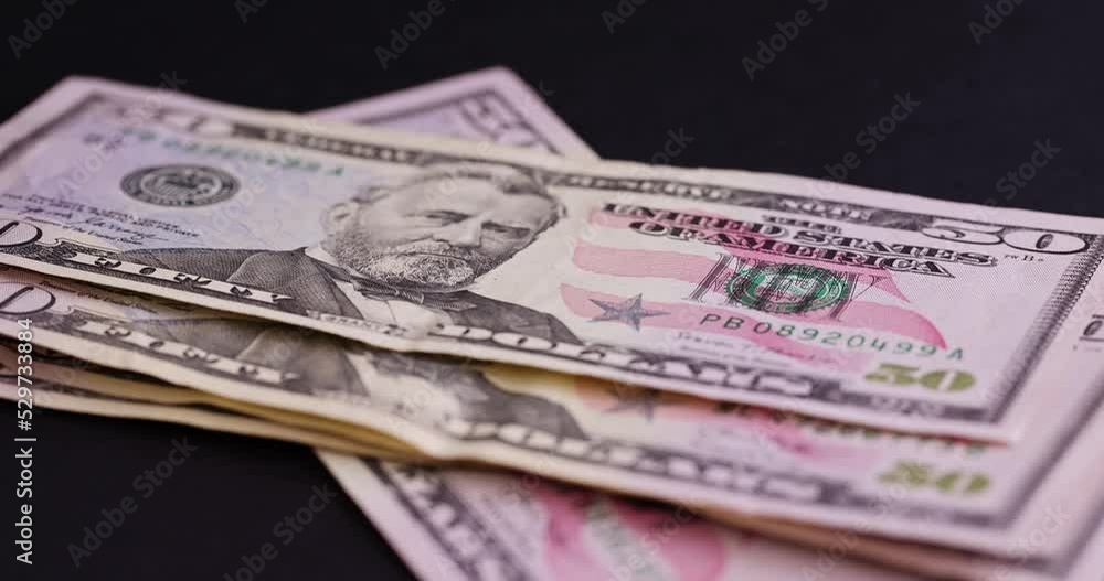 counting American fifty-dollar bills on black paper, American currency dollars in cash counting American fifty-dollar bills on black paper, American currency dollars in cash