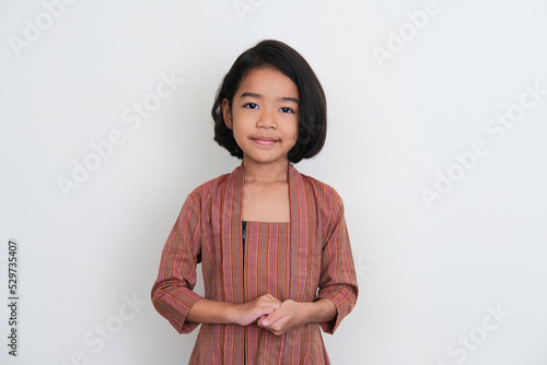 Indonesian little girl wearing traditional Javanese costume showing greeting pose