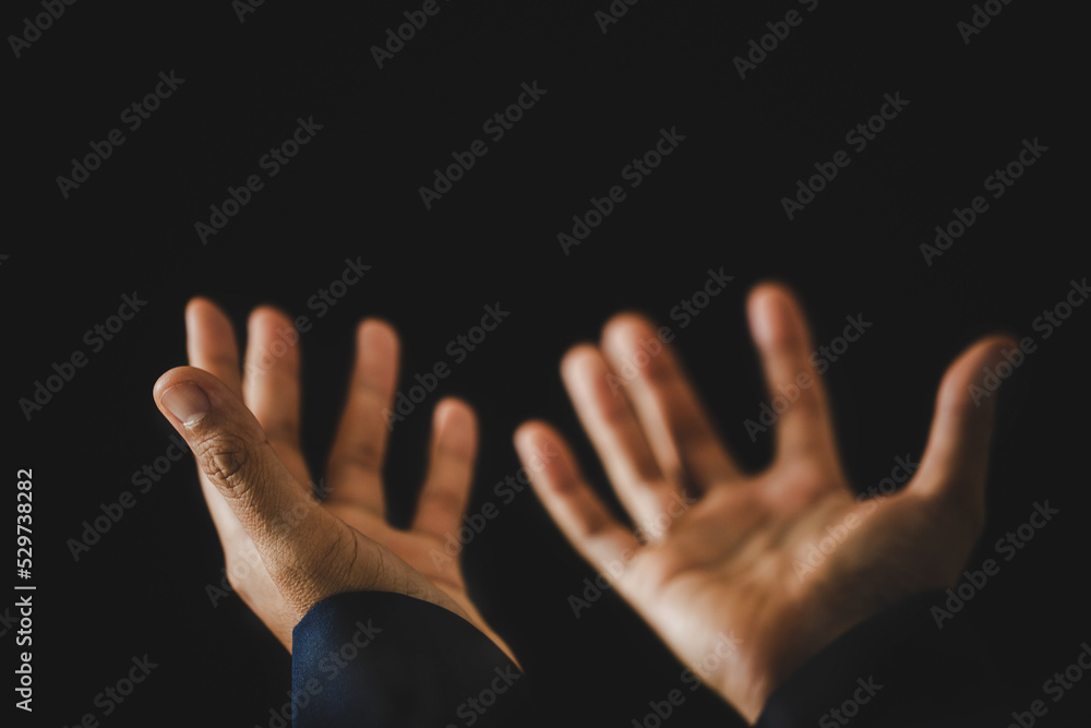 Hand folded prayer to god on dark in church concept for faith, spirituality and religion, woman person praying on holy bible in morning. Christian catholic woman hand with worship in black background.