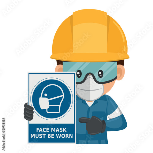 Industrial worker with a warning sign for the mandatory use of a face mask. Face mask must be worn. Industrial safety and occupational health at work
