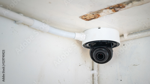 A security CCTV camera which is installed on the ceiling. Technology equipment object, selective focus.