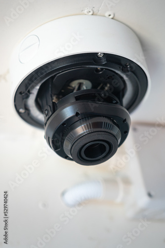 A security CCTV camera which is installed on the ceiling. Technology equipment object, selective focus.