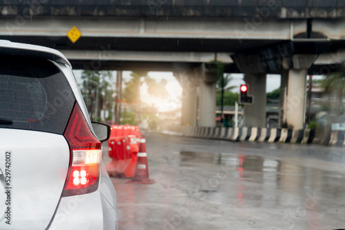 Wallpaper Mural Rear side of white car with turn signal wet with rain. Concrete road surface wet with rainy. Parked at a red traffic light under a leveled bridge. Blurred water droplets from the road surface. Torontodigital.ca