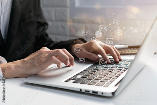 Businessman checking or sending online message on laptop with e-mail icons on background. Email marketing and newsletter, technology and lifestyle concept. Close up, copy space