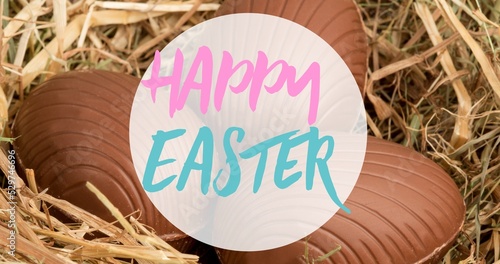 Happy easter text symbol over chocolate eggs on straw