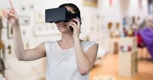 Composite image of caucasian wearing vr headset talking on smartphone against store in background