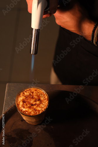 Obraz na plátně Burning Crème brûlée with a blowtorch
