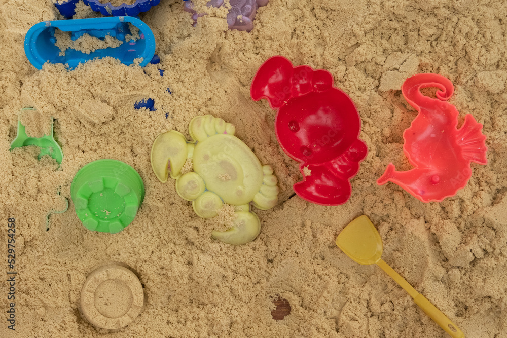 Children's sandbox with plastic toys, concept of summer games in the sand Children's sandbox with plastic toys, concept of summer games in the sand