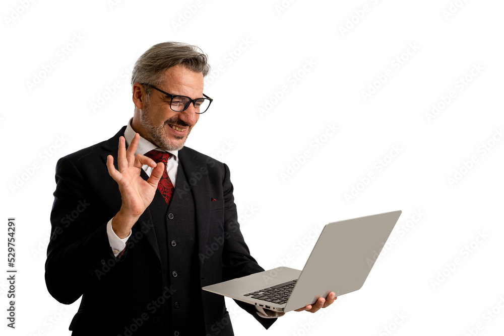 Portrait of Businessman in elegant blue suit wearing eye glasses looking at his laptop screen while holding his laptop and showing ok gesture. isolated on white background with copy space. Portrait of Businessman in elegant blue suit wearing eye glasses looking at his laptop screen while holding his laptop and showing ok gesture. isolated on white background with copy space.